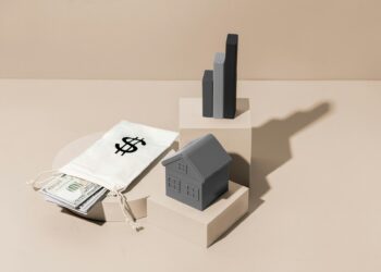 A staged image shows financial elements including a small model house on a beige block, a gray bar graph on a taller block, and a white drawstring bag with a dollar sign containing U.S. currency, symbolizing real estate investment, discount home insurance benefits, and financial growth. | MyWebInsurance